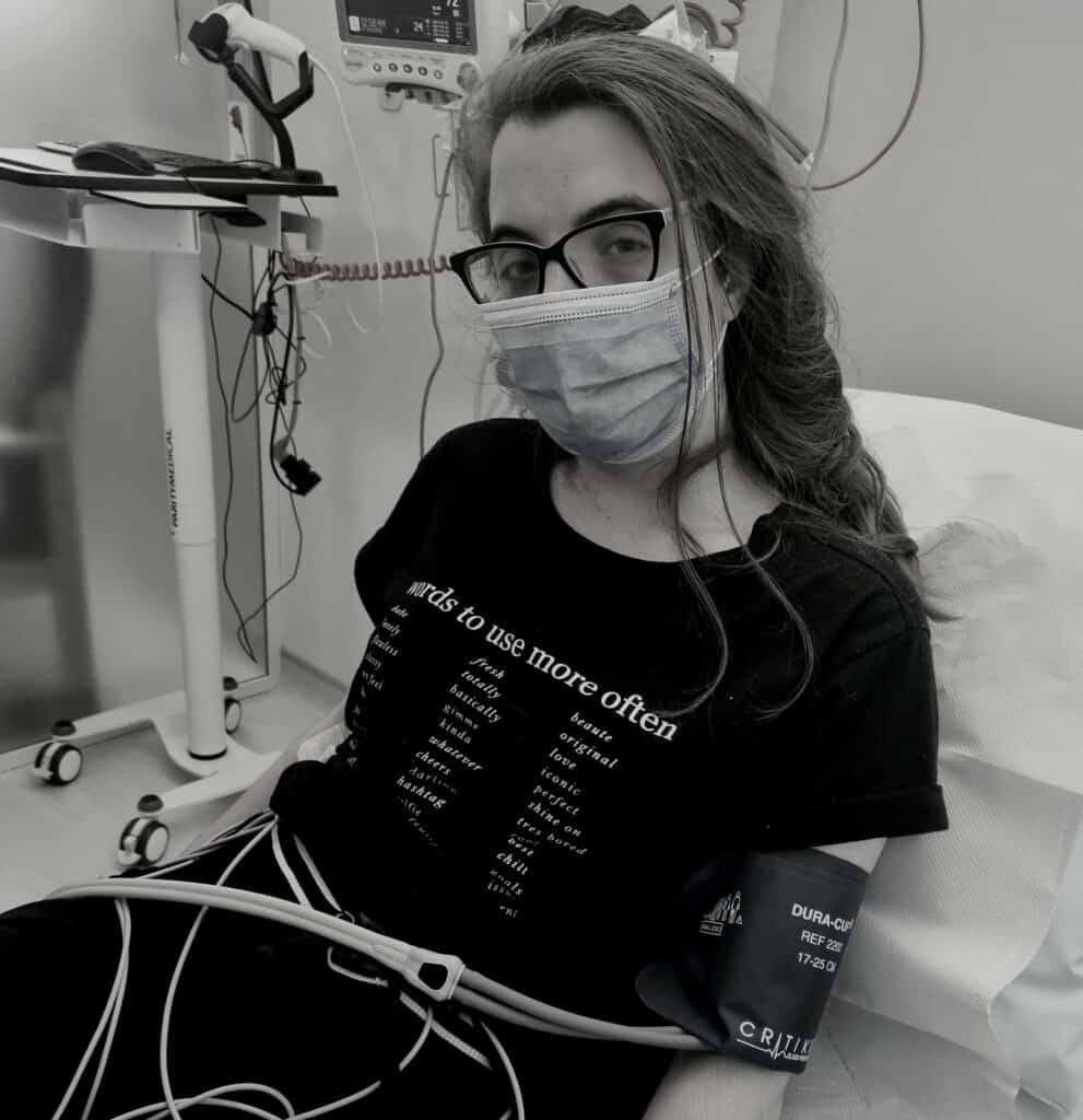 Female in hospital bed with facemask on