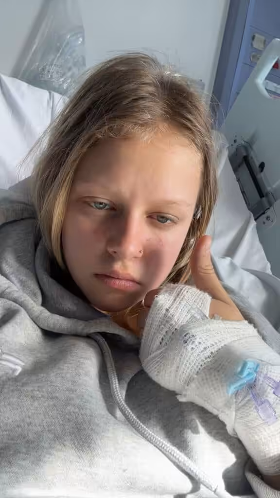 Image of Coco in hospital bed giving a thumbs up