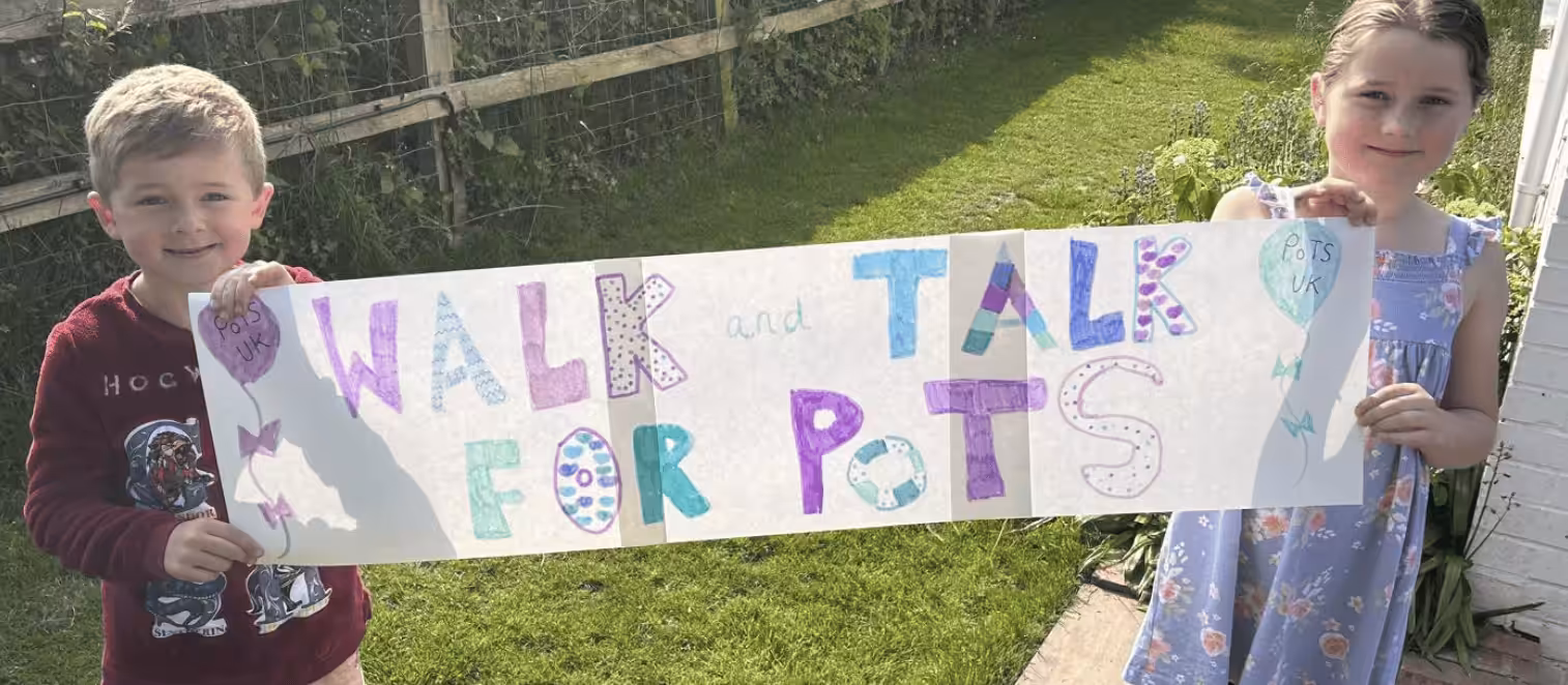 Two children holding a Walk and Talk banner