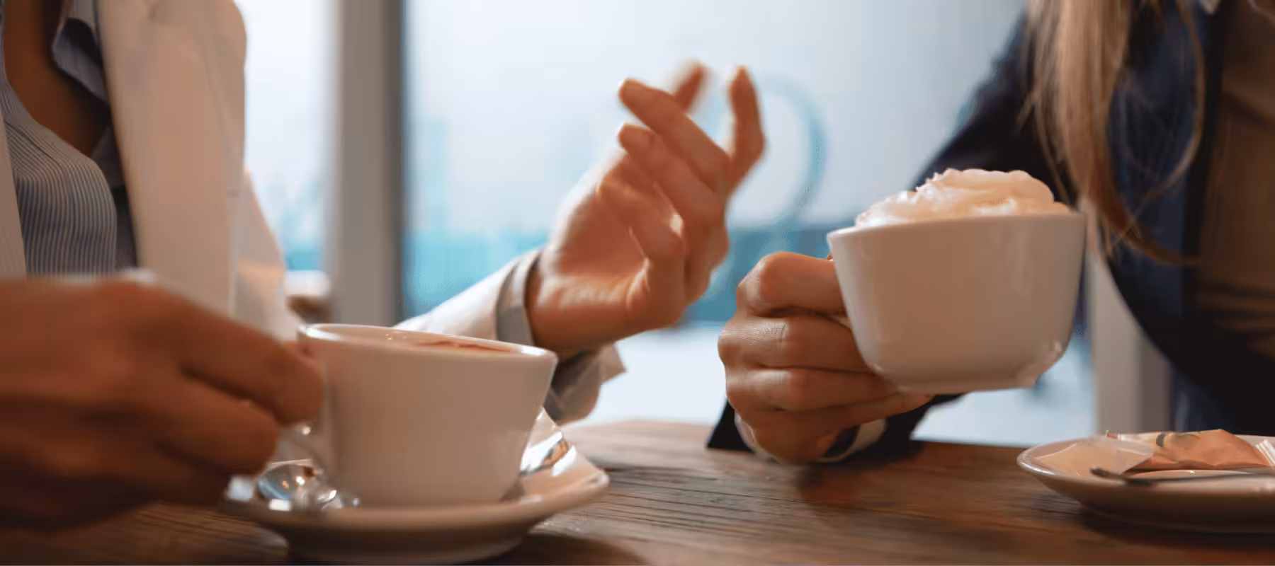 Two people talking with hot drinks